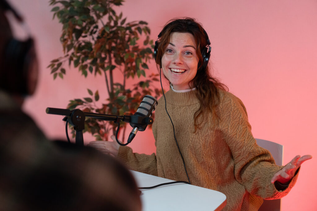 Podcast presentator enthousiast met de arme wijd.